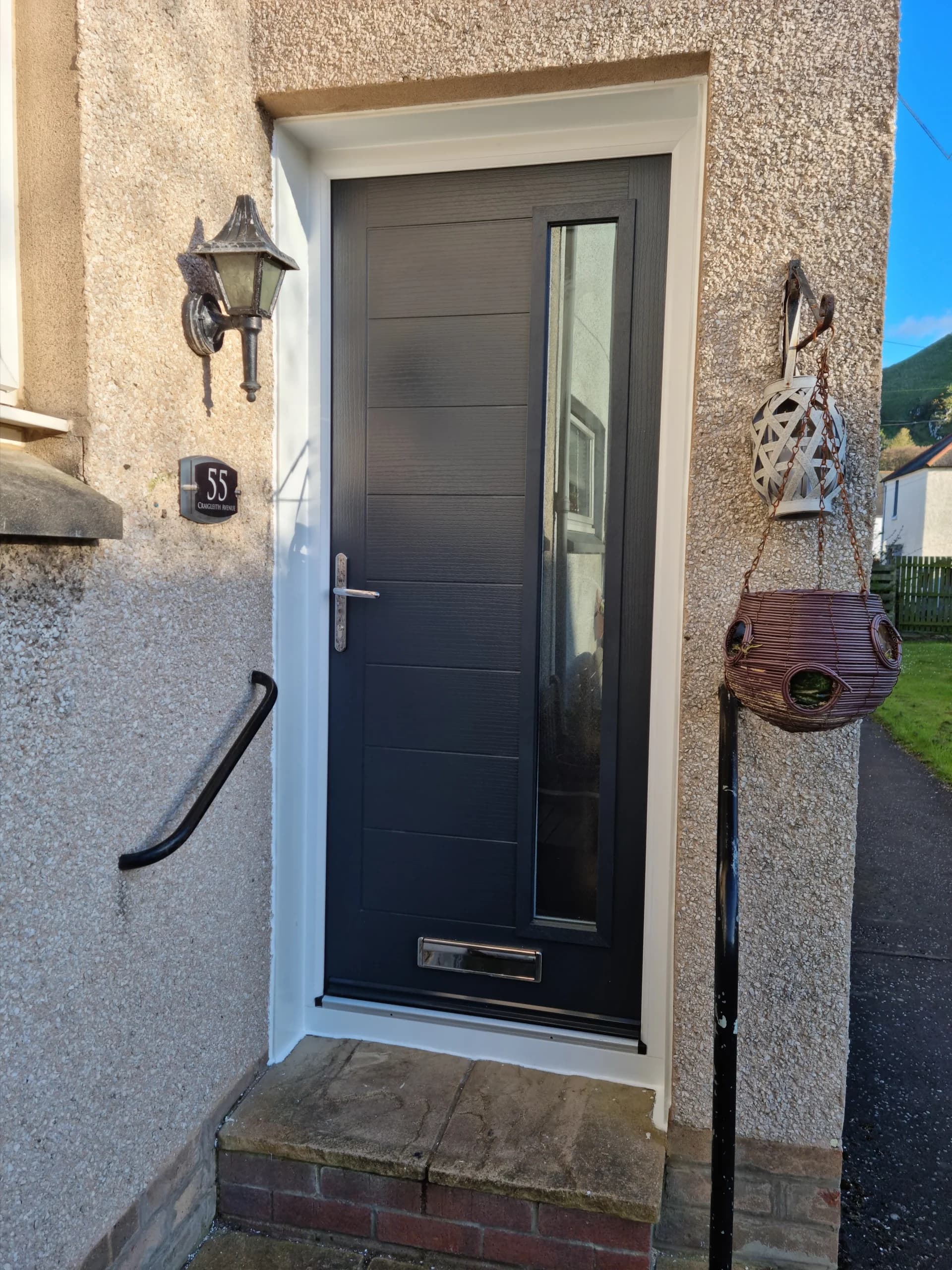 New grey composite front door fitted to a rendered house, door fitting in East Lothian by George Herkes & Son Joinery