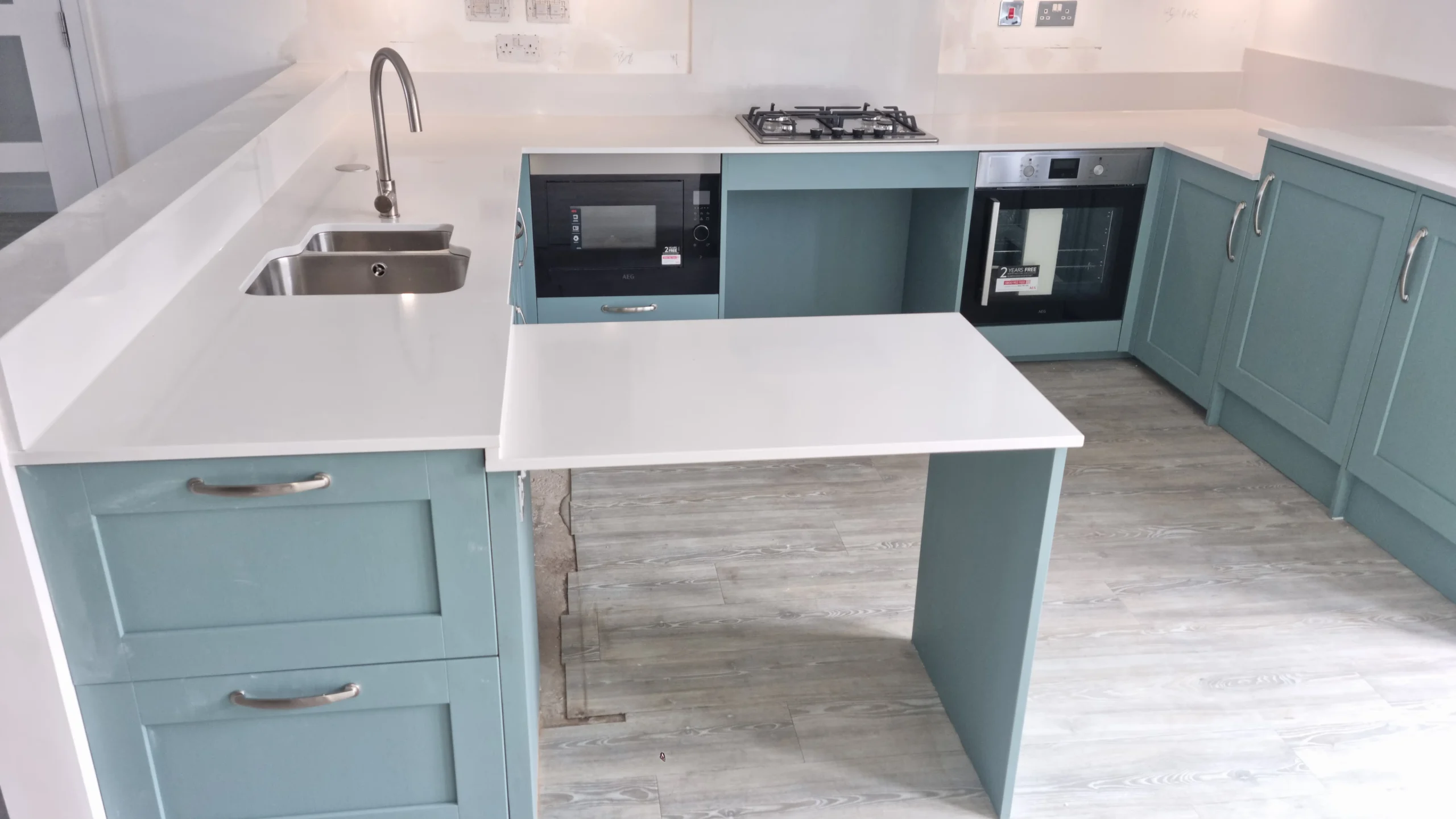 Pale blue kitchen with a breakfast bar and integrated appliances
