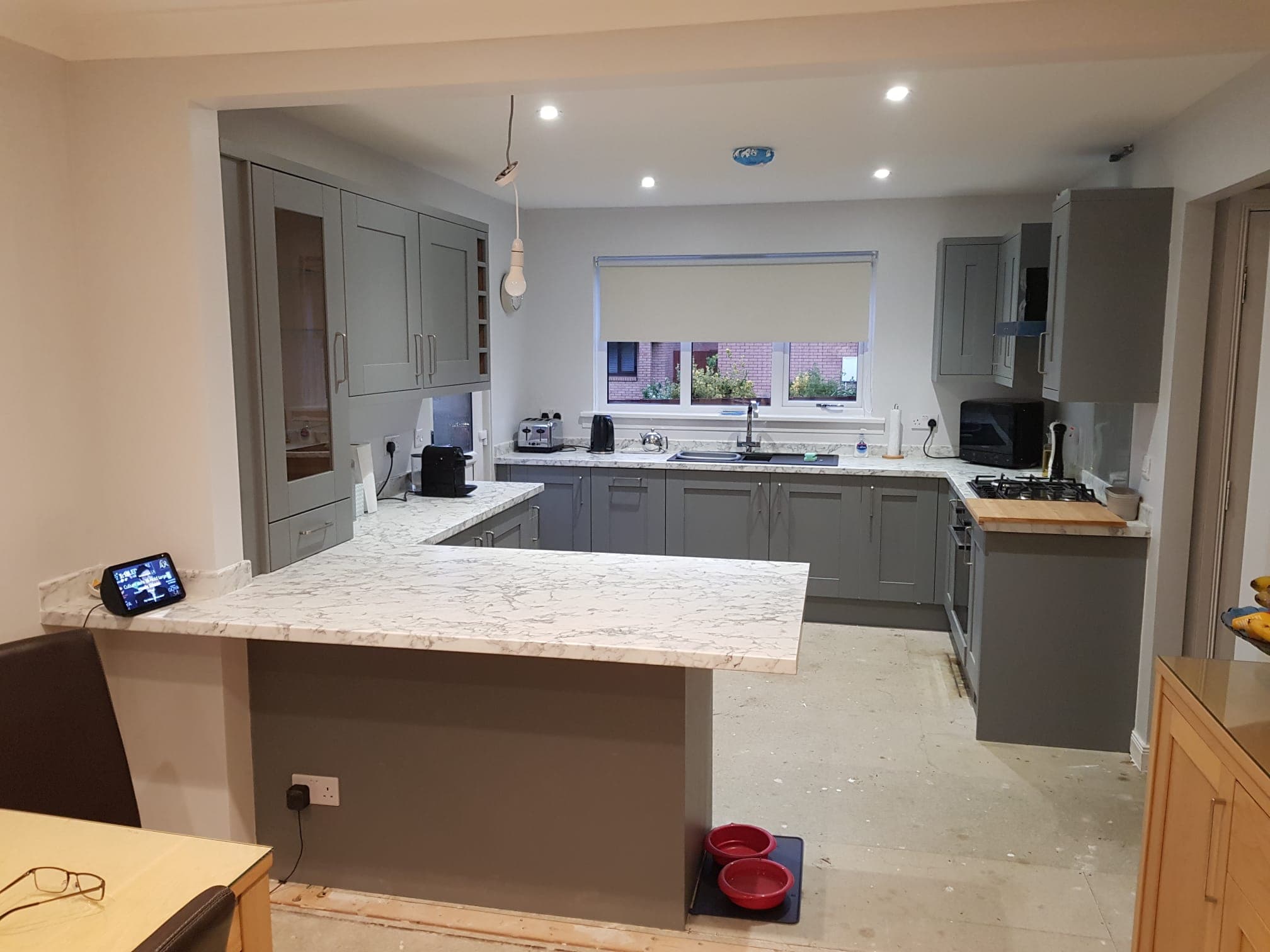 Open-plan kitchen with a stone-effect island, a home renovation North Berwick joiners can build